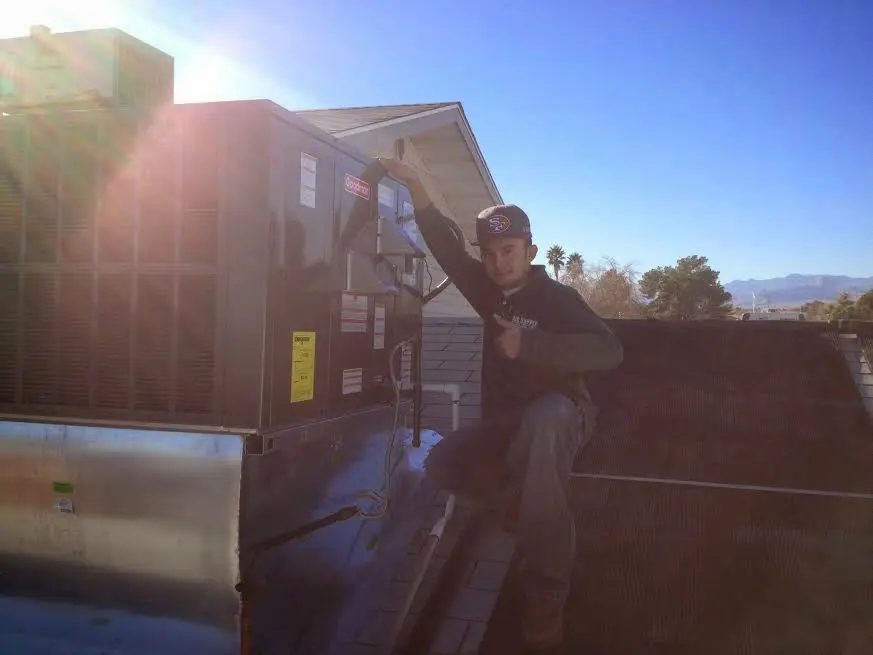 HVAC technician performing AC Tune-Up on a rooftop unit in Yucaipa